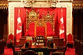 The thrones for the Canadian monarch (back left) and his or her royal consort (back right) in the Senate of Canada; these may also be occupied by the sovereign's representative, the governor general and his or her viceregal consort at the State Opening of Parliament (the speaker's chair is at centre)