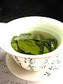 Green tea leaves steeping in an uncovered zhong