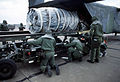 Ground crew personnel unload an aircraft engine from the rear hatch of a C-23A Sherpa.