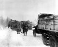 Snow and Ice make the going tough for U.S. Army vehicles on a road in Belgium. The snowstorm was responsible for the gasoline truck, at left, skidding off the road, and trucks going in the opposite direction are stalled as the result. 1st Infantry Division area, U.S. First Army. Sourbrodt, Belgium. 19 Jan 1945